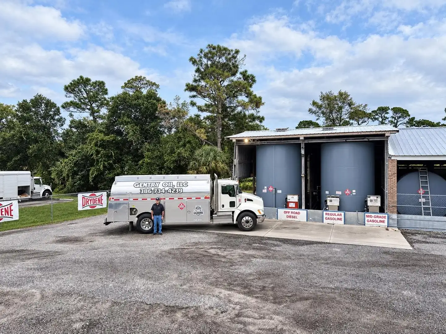 Gentry Oil owner standing beside the company tanker truck at the fuel depot, next to the diesel and gasoline pumps