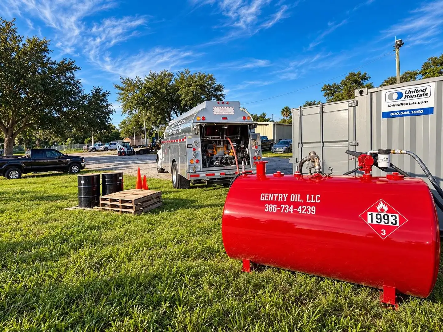 Red Gentry Oil fuel tank beside a United Rentals container on a job site, with the Gentry Oil tanker truck